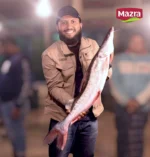 A man holding a big ayre fish in bangladeshi market
